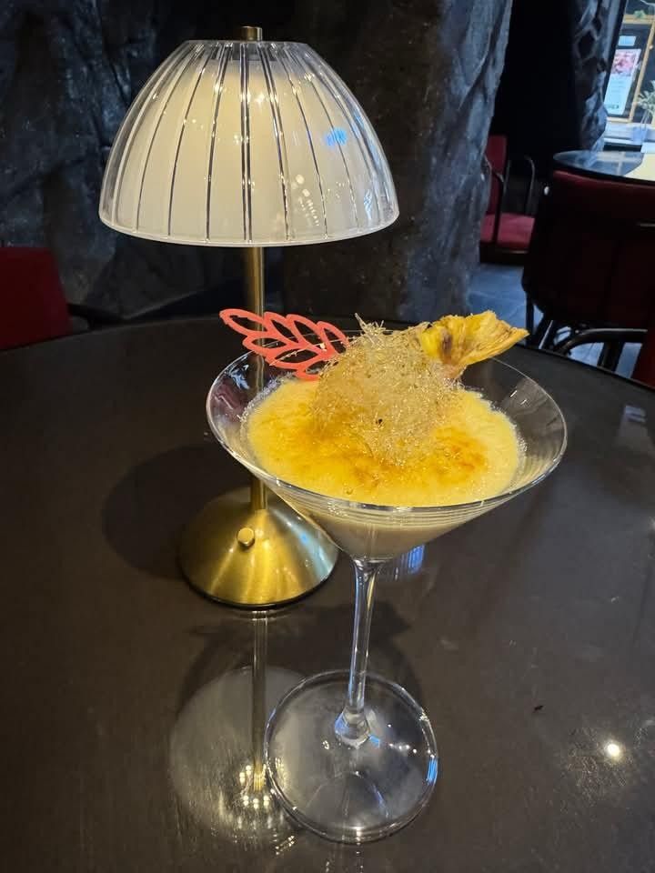 Creme brulee with a torched top, spun sugar and dried pineapple, served in a martini glass
