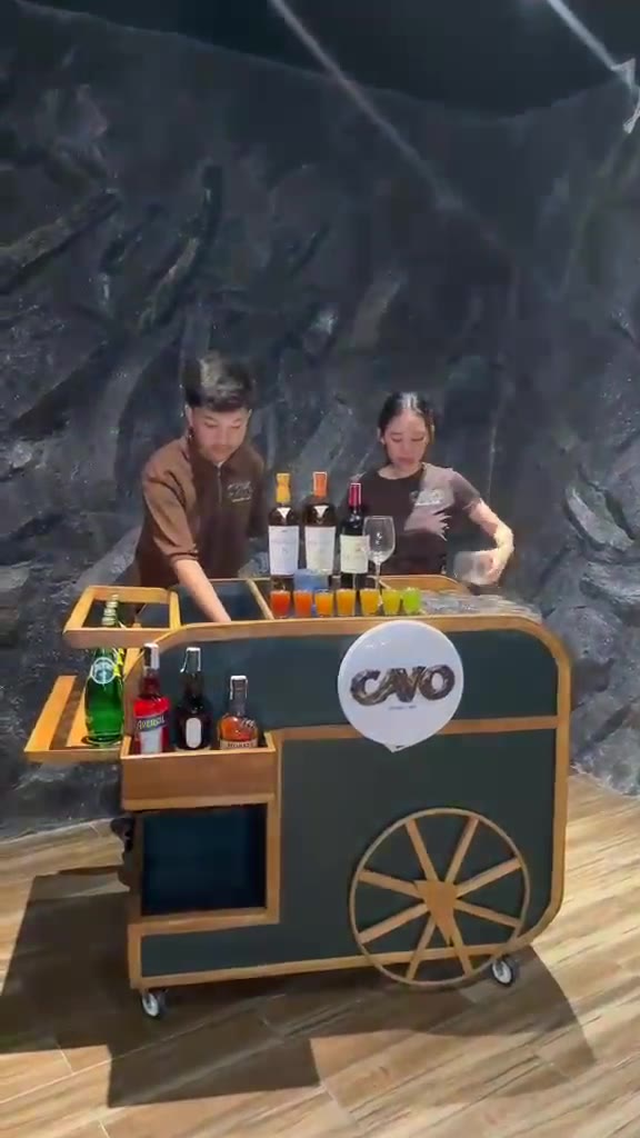 The wooden Cavo Mobile Bar cart serving drinks